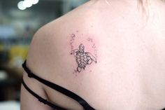 a woman with a tattoo on her shoulder has a turtle and bubbles in the water