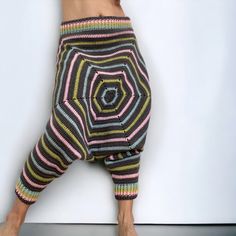 a person with their legs crossed wearing colorful knitted pants