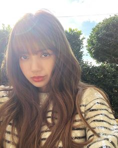 a woman with long brown hair is posing for the camera