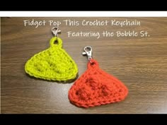 two crocheted keychains sitting on top of a wooden table