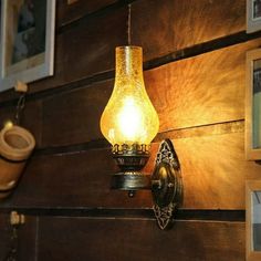 a light that is on the side of a wooden wall next to pictures and other items