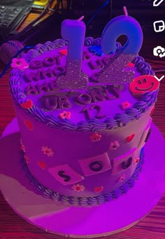 a purple birthday cake sitting on top of a table