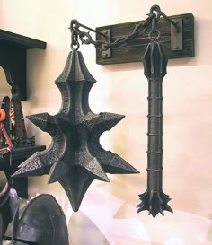 an iron star hanging from a chain next to other items on a shelf in a room