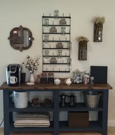 there is a shelf with many items on it in the room that includes cups and mugs