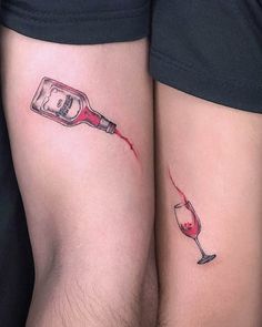 two people with tattoos on their legs holding wine glasses