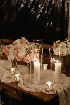 candles are lit on a table with flowers