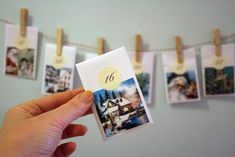 someone holding up a card with pictures hanging from it