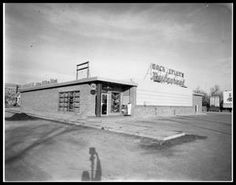 an old black and white photo of a building with a person standing in front of it