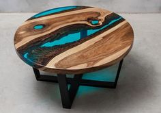 a table made out of wood and blue glass in the shape of an ocean wave