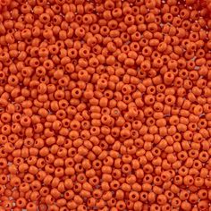 orange beads are arranged in rows on a white surface