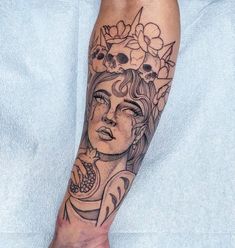 a woman's leg with a tattoo on it that has skulls and flowers around her head