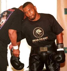 two men in black shirts and boxing gloves