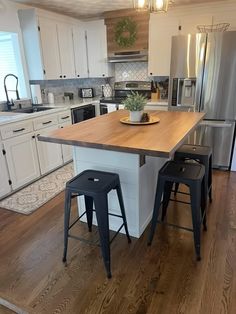 a kitchen island with two stools in front of it