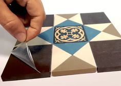 a person is cutting up some tiles with scissors