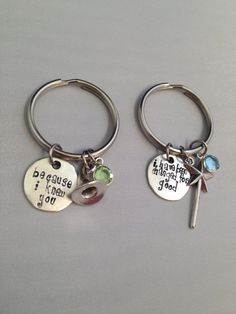 two silver key chains with charms on them