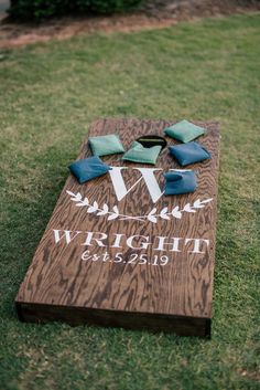 a cornhole board with blue and green napkins on it sitting in the grass