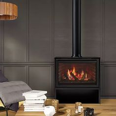 a living room with a fire place next to a chair and lamp on the floor