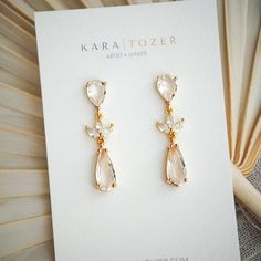 Our tiered CZ bridal dangles are one of our most popular earrings for brides. Designed with teardrop posts and dainty leaf shaped CZ stones that descend into a beautiful teardrop crystal. The earring posts are created with 925 sterling silver.  Size: Approximately 1.75 inches from top to bottom  KARA | TOZER offers handmade clay and gold jewelry for everyday and special occasions. All of our everyday styles are inspired by neutral tones that will pair beautifully with any outfit. Items are restocked weekly but feel free to send a message if a certain style or color is sold out. FREE SHIPPING on orders $35 and up. Thank you for shopping small and handmade from York, Pennsylvania! You can also find us on the web at WWW.KARATOZER.COM and in several local boutiques across southcentral PA. THE Pearl Drop Danglers For Wedding, Wedding Pearl Drop Danglers, Gold Teardrop Danglers For Wedding, Wedding Danglers, Brides Earrings, Modern Bridal Earrings, Bridal Earrings Statement, Boho Bridal Earrings, Bridal Statement Earrings