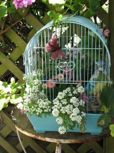 a birdcage filled with flowers and butterflies