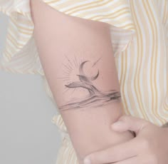 a woman's arm with a bird tattoo on the left side of her arm