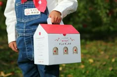 a young child holding a box with two pairs of shoes in it's pocket