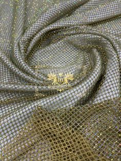 a close up view of a fabric with gold sequins on it