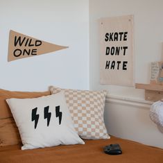 a bed with two pillows on it next to a wall hangings and a remote control