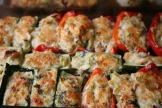 zucchini stuffed with cheese and red peppers on a baking sheet in the oven