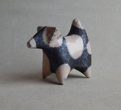 a ceramic figurine of a small animal with spots on it's body