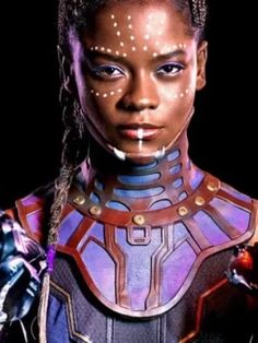 a woman with dreadlocks and makeup is wearing a futuristic suit in front of a black background