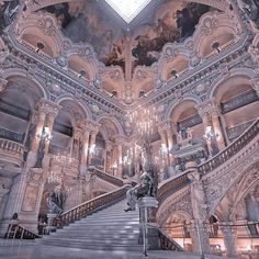 an ornate building with stairs and chandeliers