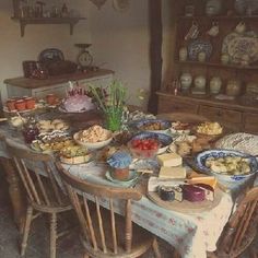 a dining room table covered in plates and bowls filled with different types of food on top of it