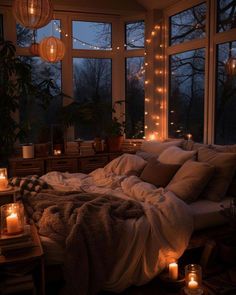 a bedroom with candles lit up in the windows