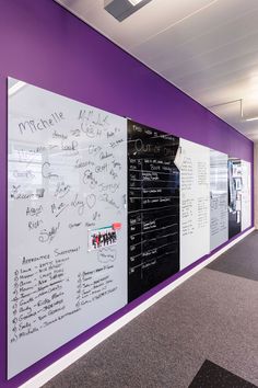 an office wall with writing on it and purple accenting the walls, along with whiteboard