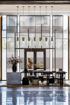 a dining room table and chairs in front of a large window with bars on it