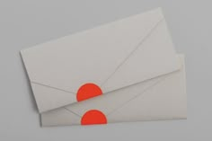 an envelope with two red circles on the front and one orange circle on the back