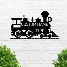 a train is shown on the side of a brick wall with trees in front of it