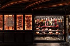 the meat shop is lit up with red lights and hanging racks full of meats