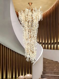 a large chandelier hanging from the ceiling in front of a spiral stair case