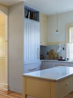 a kitchen with an island in the middle and cupboards on both sides that are open