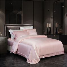 a bed with pink sheets and pillows in a dark room next to a mirror on the wall