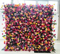 an artificial flower wall is shown in front of a window with flowers all over it