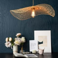 a table topped with flowers and pictures next to a light fixture hanging from the ceiling