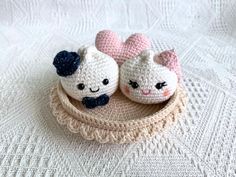 two crocheted stuffed animals sitting on top of a white blanket