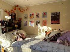 a bedroom with pictures on the wall and stuffed animals on the bed