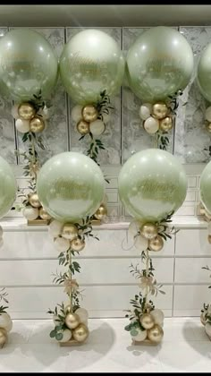 green and gold balloons with greenery on them