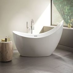 a bathroom with a large white bathtub next to a sink