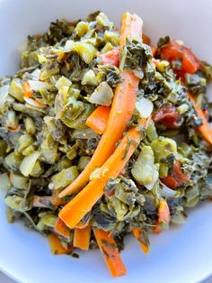 a white bowl filled with vegetables on top of a table