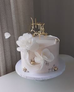 a birthday cake with white flowers on top