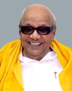 an older man wearing sunglasses and a yellow jacket